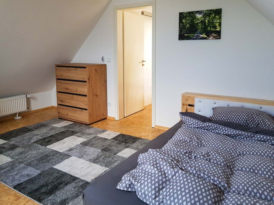 Schlafzimmer mit Doppelbett, Kommode und Dachschräge
