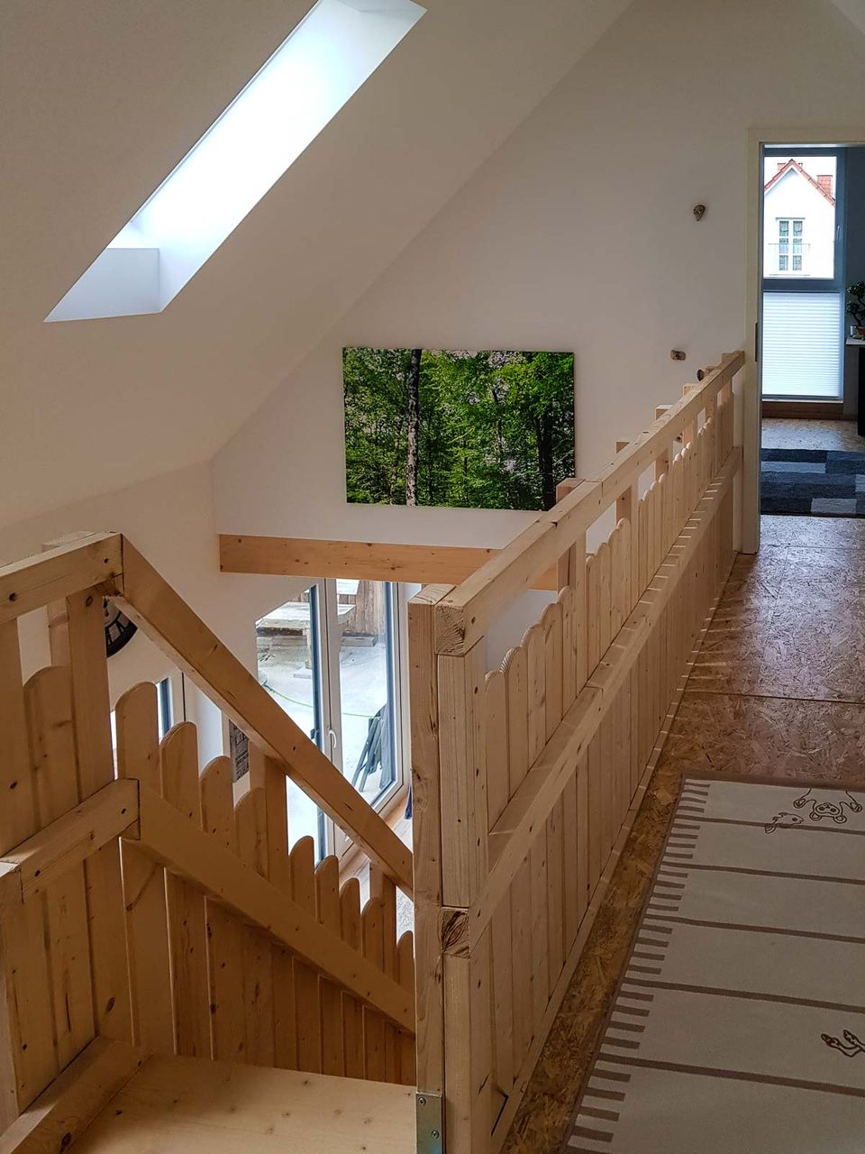 Galerie mit Holzgeländer und Blick über die Treppe ins Erdgeschoss