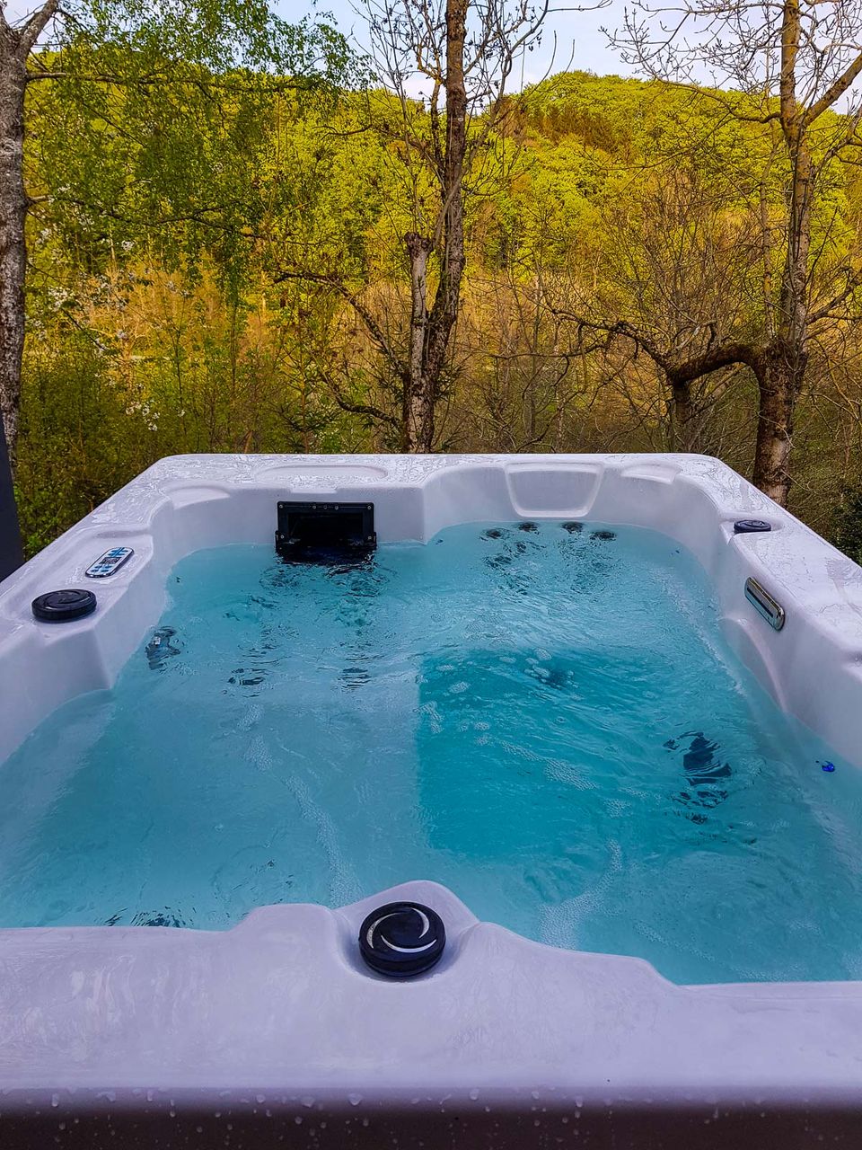Außenwhirlpool im Freien mit Blick in den herbstlich gefärbten Wald