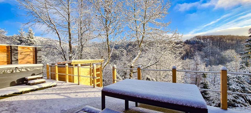 Verschneite Terrasse des Chalets mit Blick in die winterliche Rhön